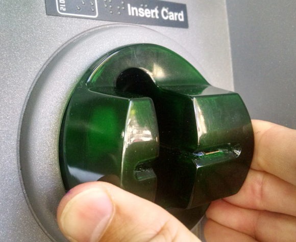 Notice the left side of this card skimmer overlay starts to pull away from the rest of the facade when squeezed. Also note the presence of a circuit board close to the mouth of the fake bezel.